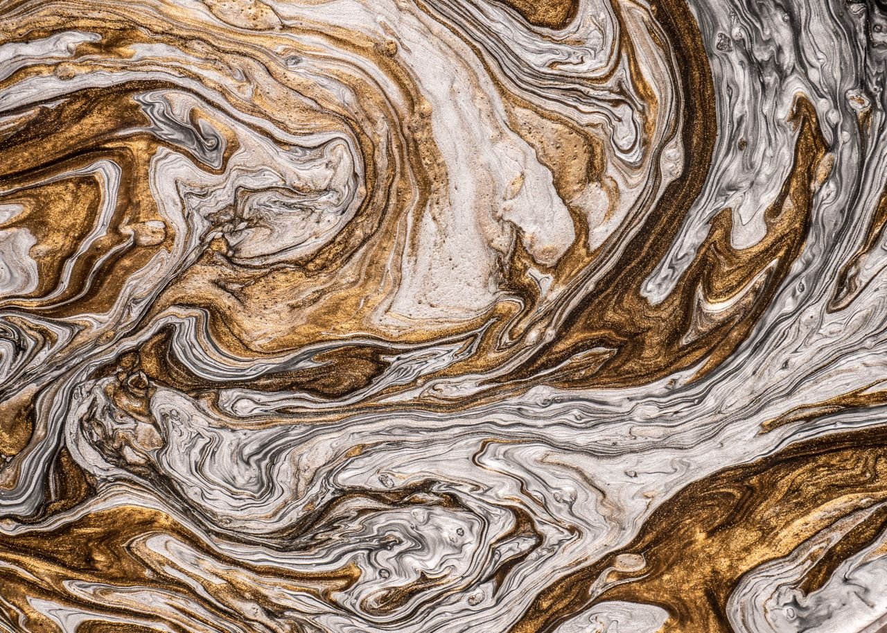 Swirling abstract marble texture featuring gold and white patterns, ideal for backgrounds and design projects.